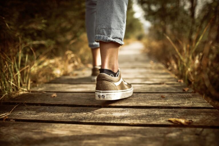 Close-up of shoes walking on a wooden dock, symbolizing journey and reflection Counseling for recovery in Blaine MN