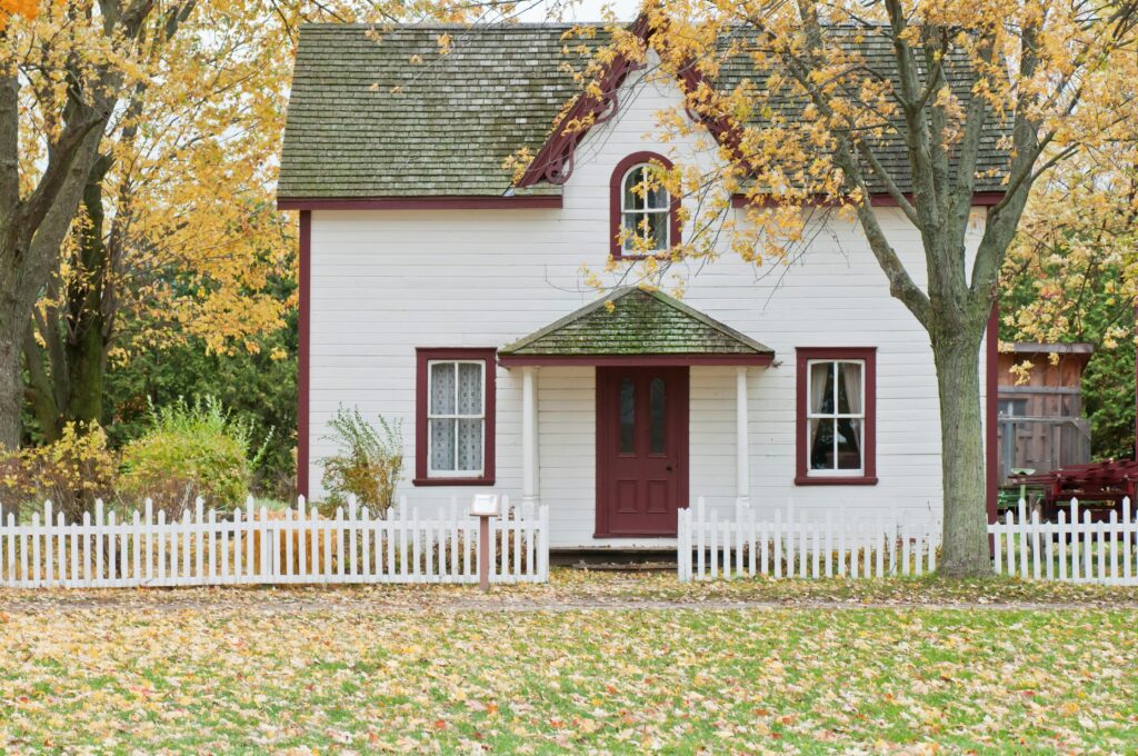 Small white house with a white picket fence, symbolizing home, stability, and comfort Therapist in Blaine MN