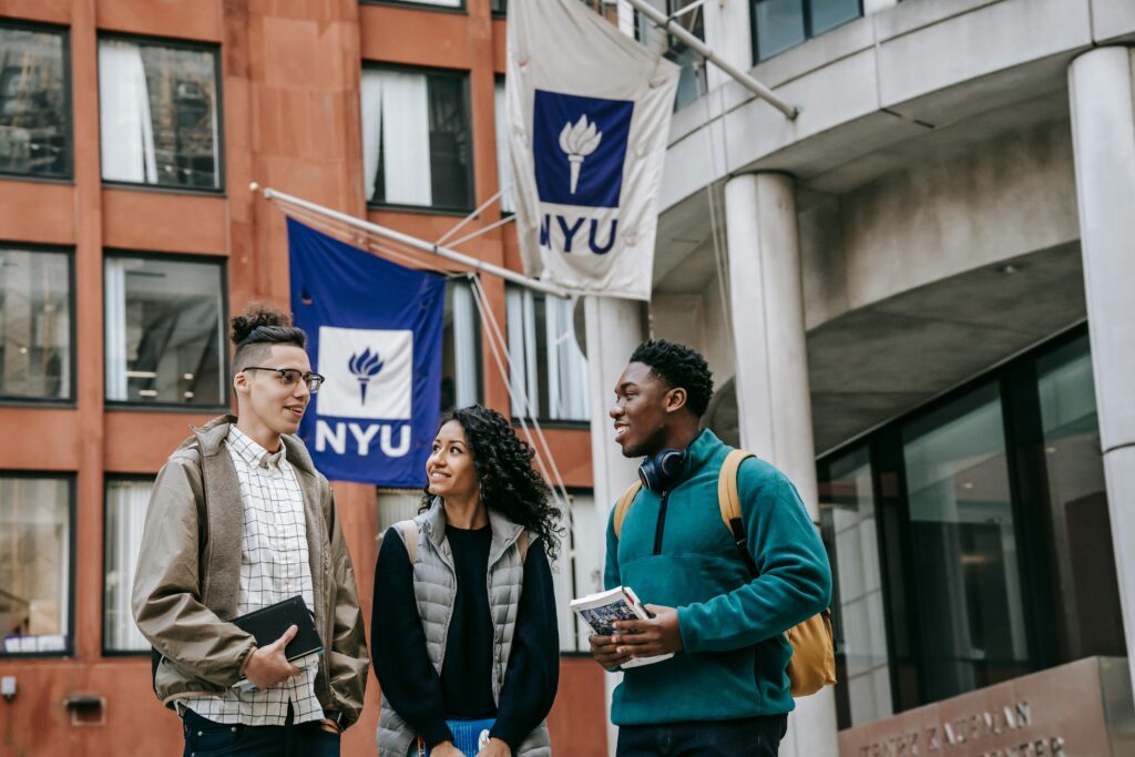 Diverse group of college students talking outside NYU, reflecting university life and diversity.