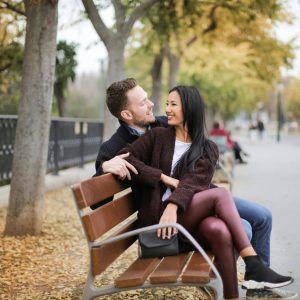 Couple on park bench in sitting staring at each other with smile on their faces Therapy in Blaine MN
