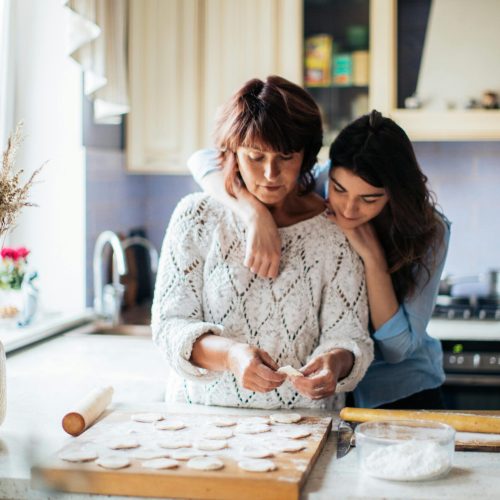 pexels-photo-3893532-3893532 A mother and daughter bond while preparing traditional dumplings in a cozy kitchen setting.