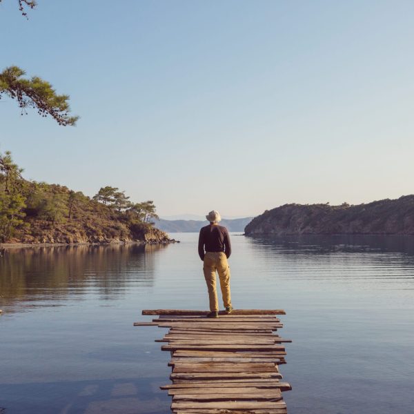 A man is resting at ease by the calm lake. Relaxation vacation