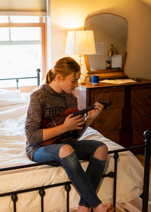 Teenage girl playing her violin in her bedroom
