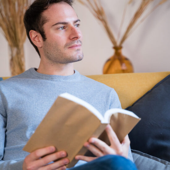 Navigating Divorce in Blaine MN Man reading a book on the couch
